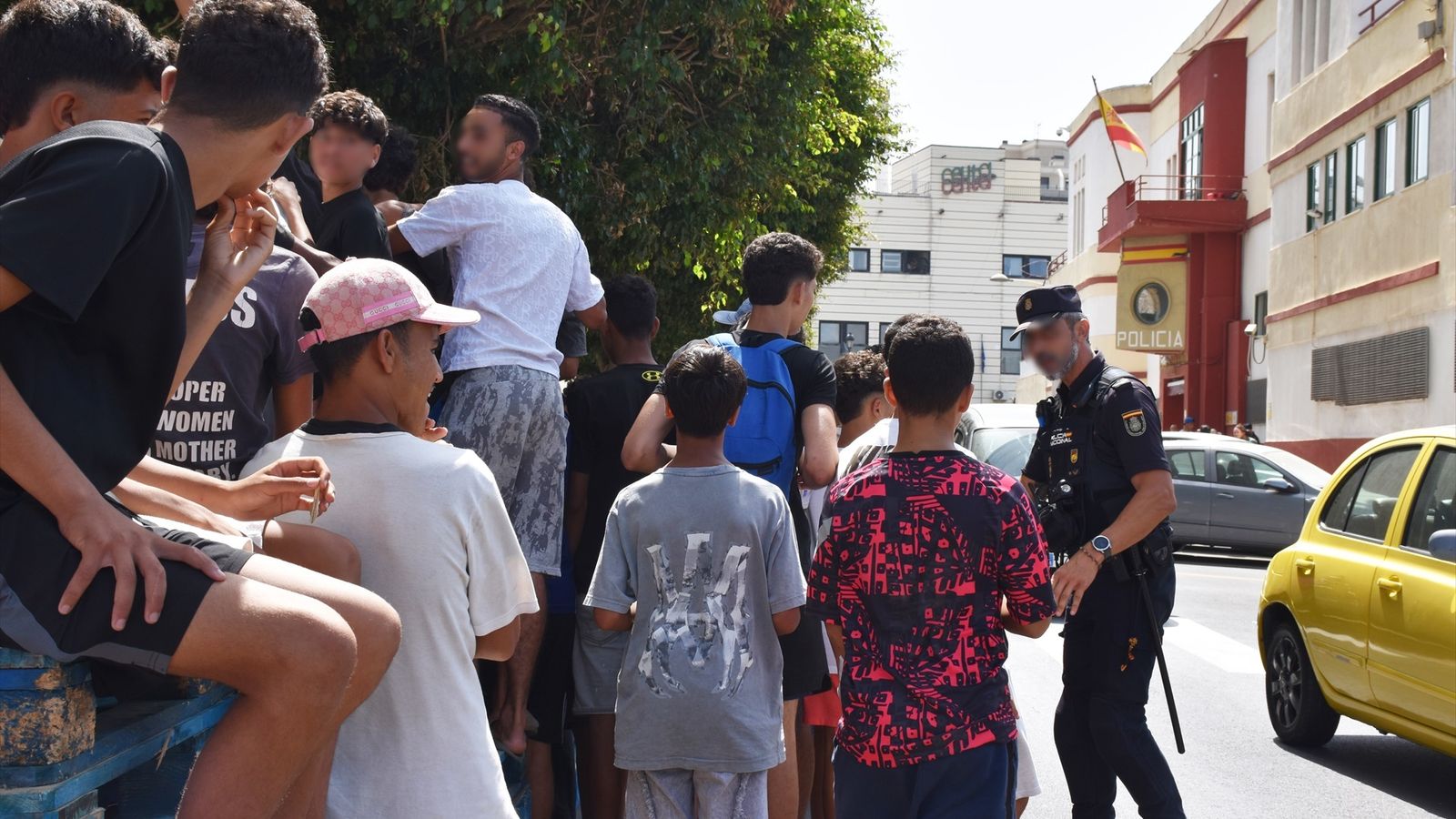 Un grup de menores espera per a ser filiat en una comissaria de la Policía Nacional a Ceuta
