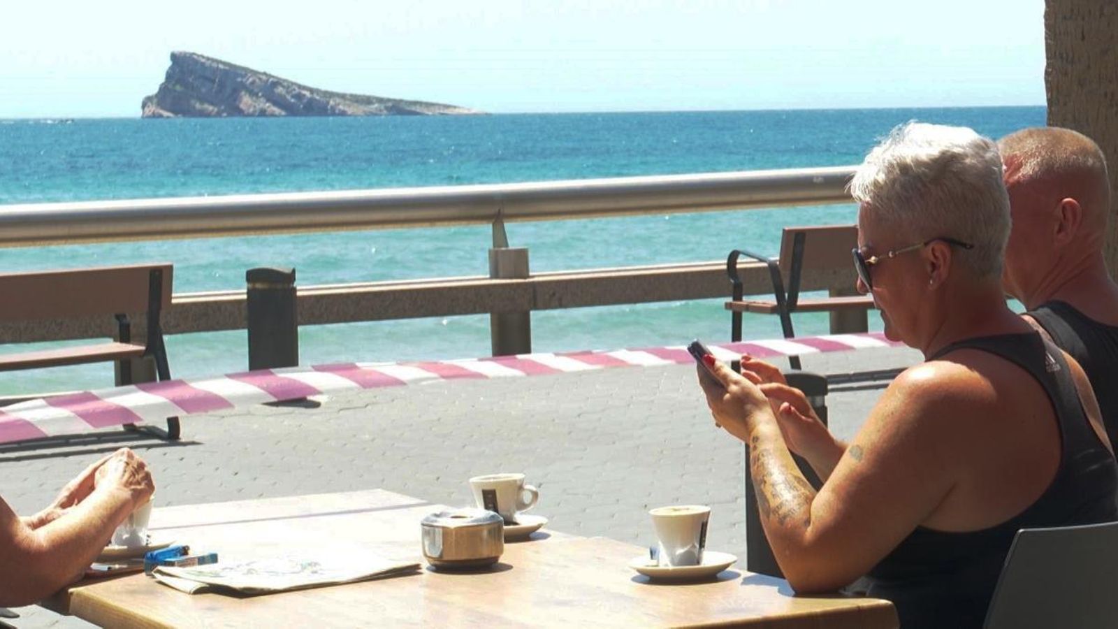 Turistes asseguts en una terrassa vora mar a Benidorm, a la Marina Baixa