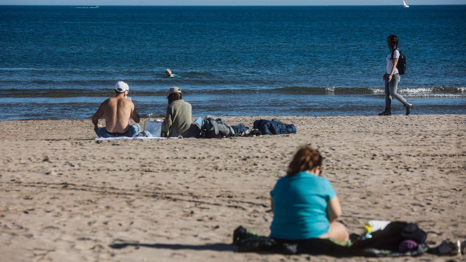 Diverses persones gaudeixen de les altes temperatures a la platja