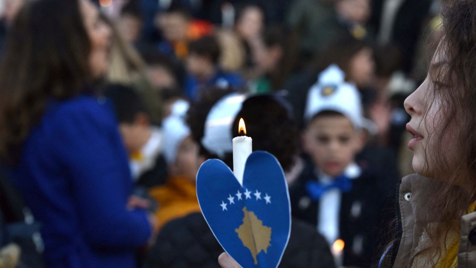 Una persona sosté una de les 1133 espelmes per a recordar els xiquets morts durant la guerra kosovar