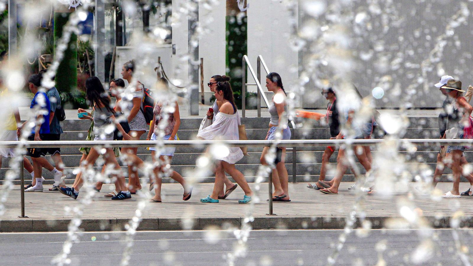 Diverses persones passen pel costat d'una font a Alacant