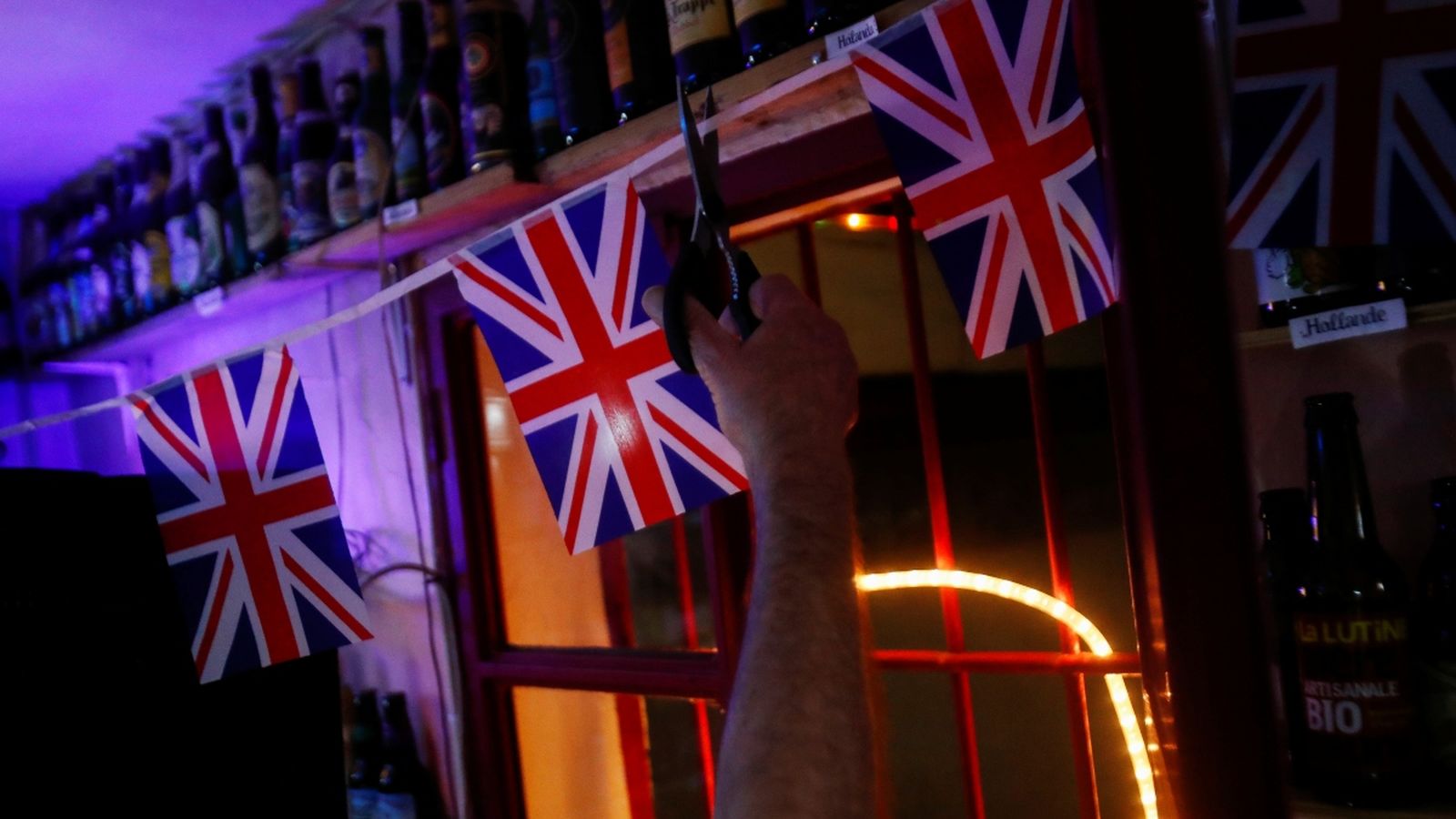 Un britànic talla el cordó de les banderes britàniques a un bar espanyol com a símbol del Brexit amb Europa