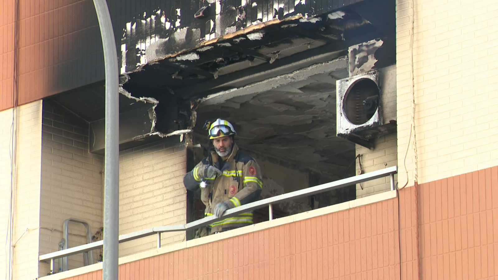 Un dels bombers treballa en l'extinció de l'incendi que ha causat la mort a una dona aquest divendres al barri de Nazaret de València