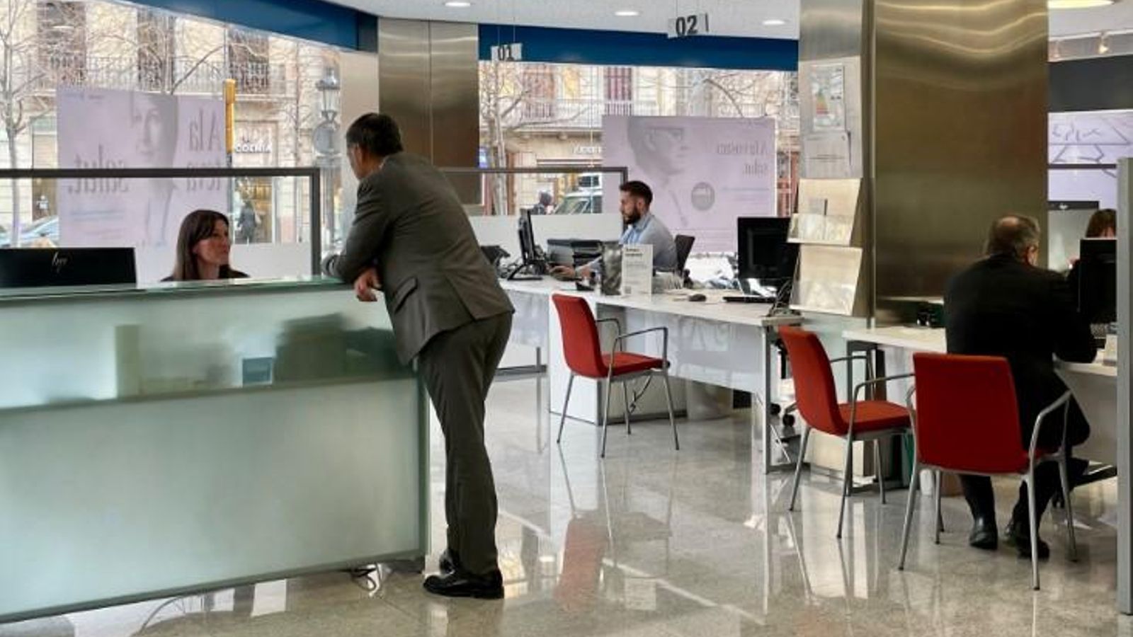 Treballadors i clients en una oficina del Banc Sabadell