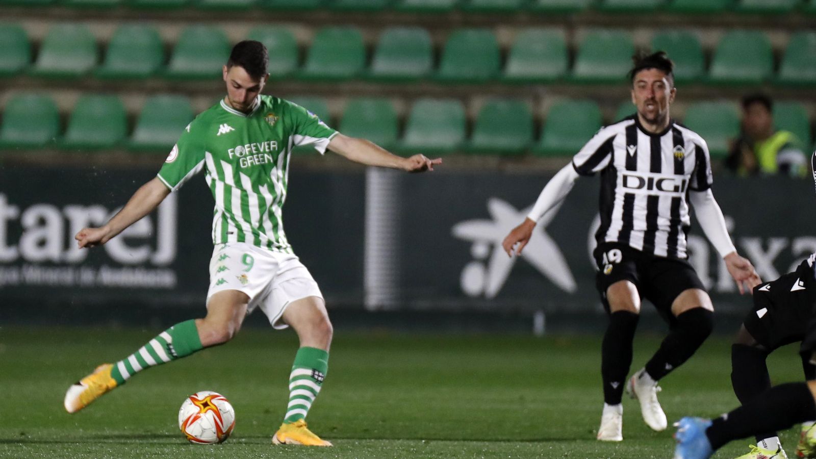 Un jugador del Betis colpeja el baló davant la mirada de Pablo Hernández, del Castelló