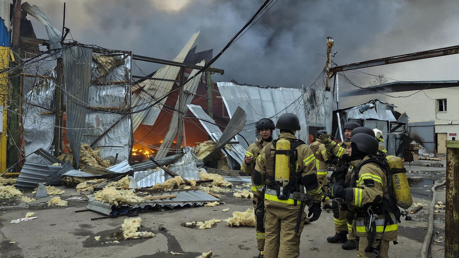 Els bombers junt a algunes naus que han patit els efectes de l'últim atac rus sobre la capital ucraïnesa