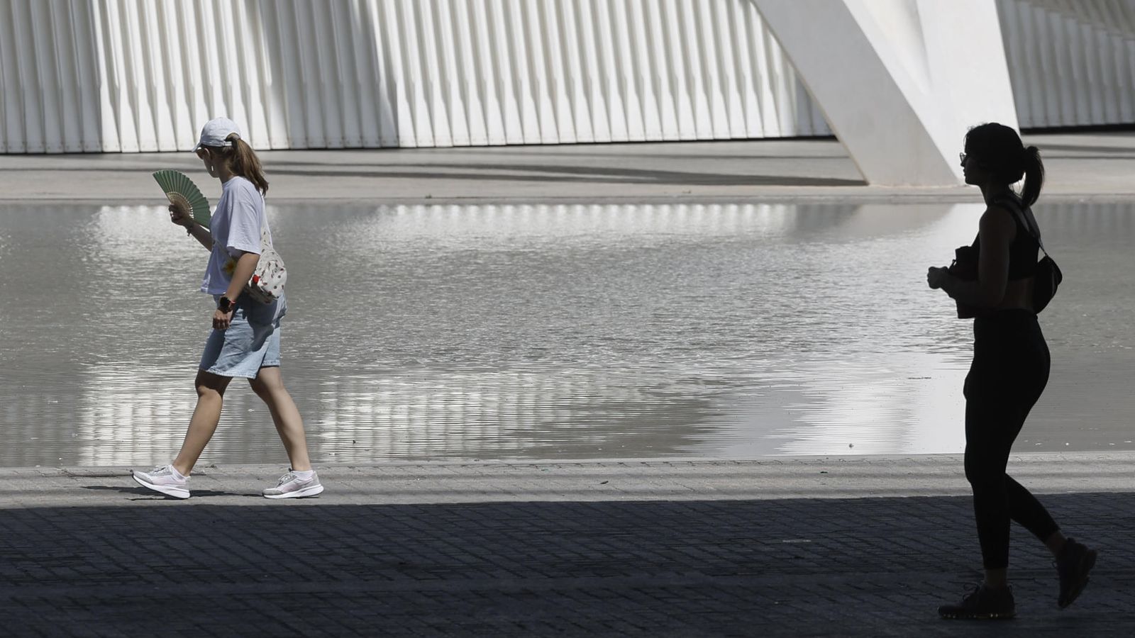 Una dona es venta mentre passeja per la Ciutat de les Arts i les Ciències de València