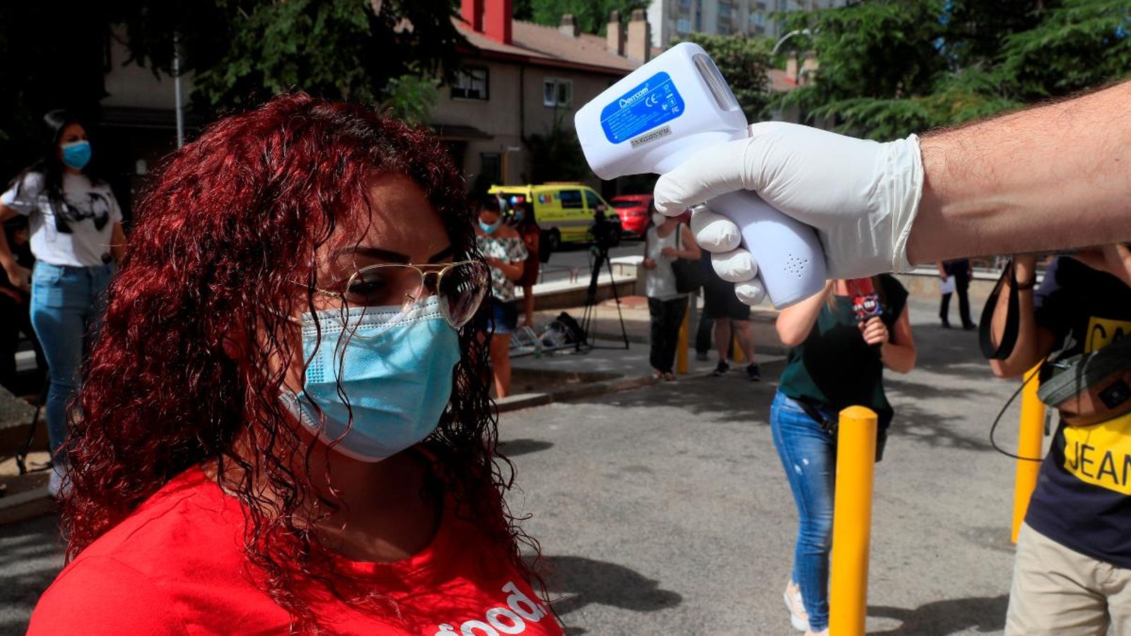 Personal sanitari pren la temperatura a una dona abans de sotmetre's a un test PCR