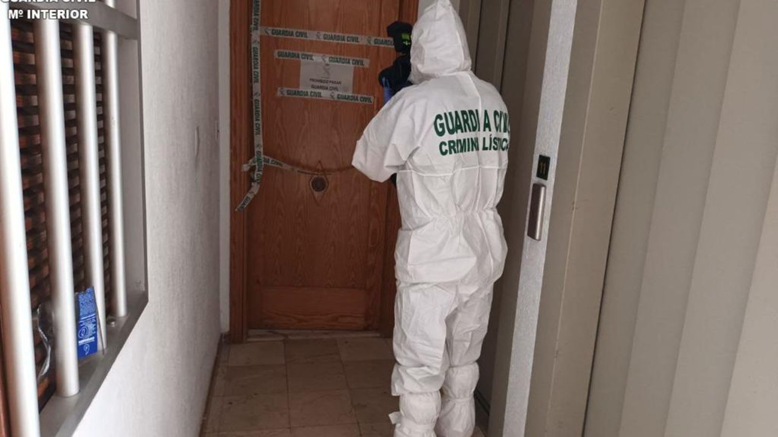 Un agent a la porta del domicili de la víctima a Cullera