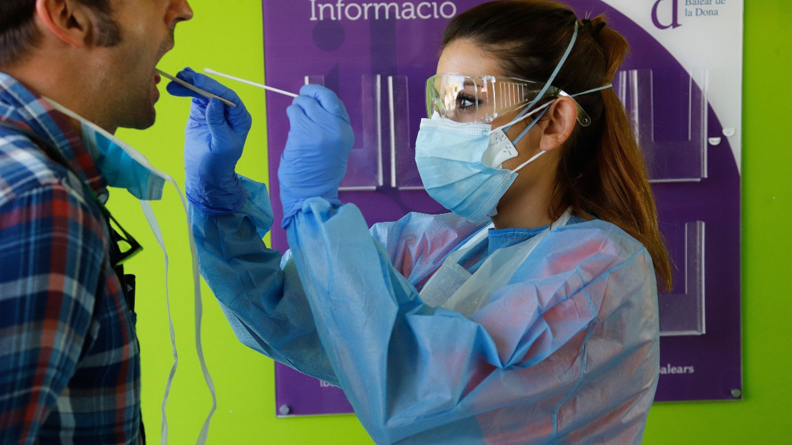 Una sanitària toma mostres a un pacient per a fer-li una prova PCR de detecció del coronavirus