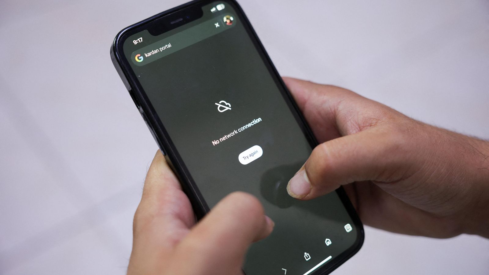 Un home intenta infructuosament connectar-se a Internet a través del seu telèfon