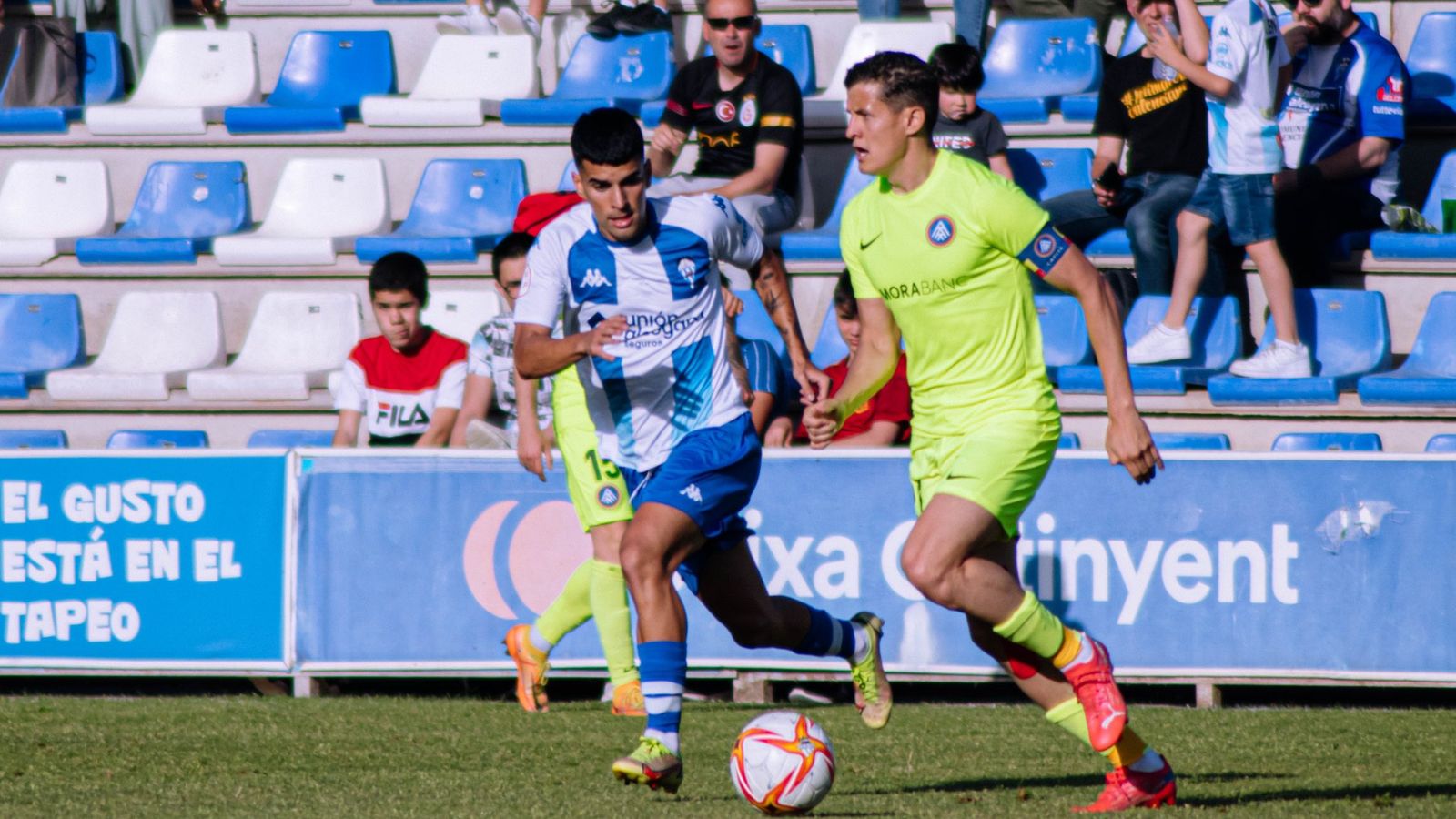 El capità de l'Andorra avança amb el baló davant la pressió d'un jugador de l'Alcoià