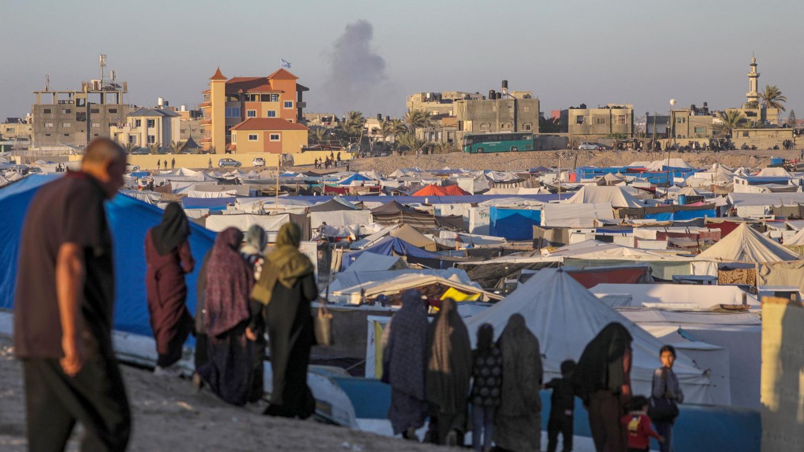 Desplaçats interns palestins albiren des d'un campament el fum derivat d'un atac aeri israelià a Rafah