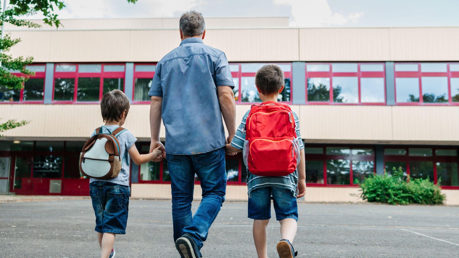 Un pare porta els fills a l'escola