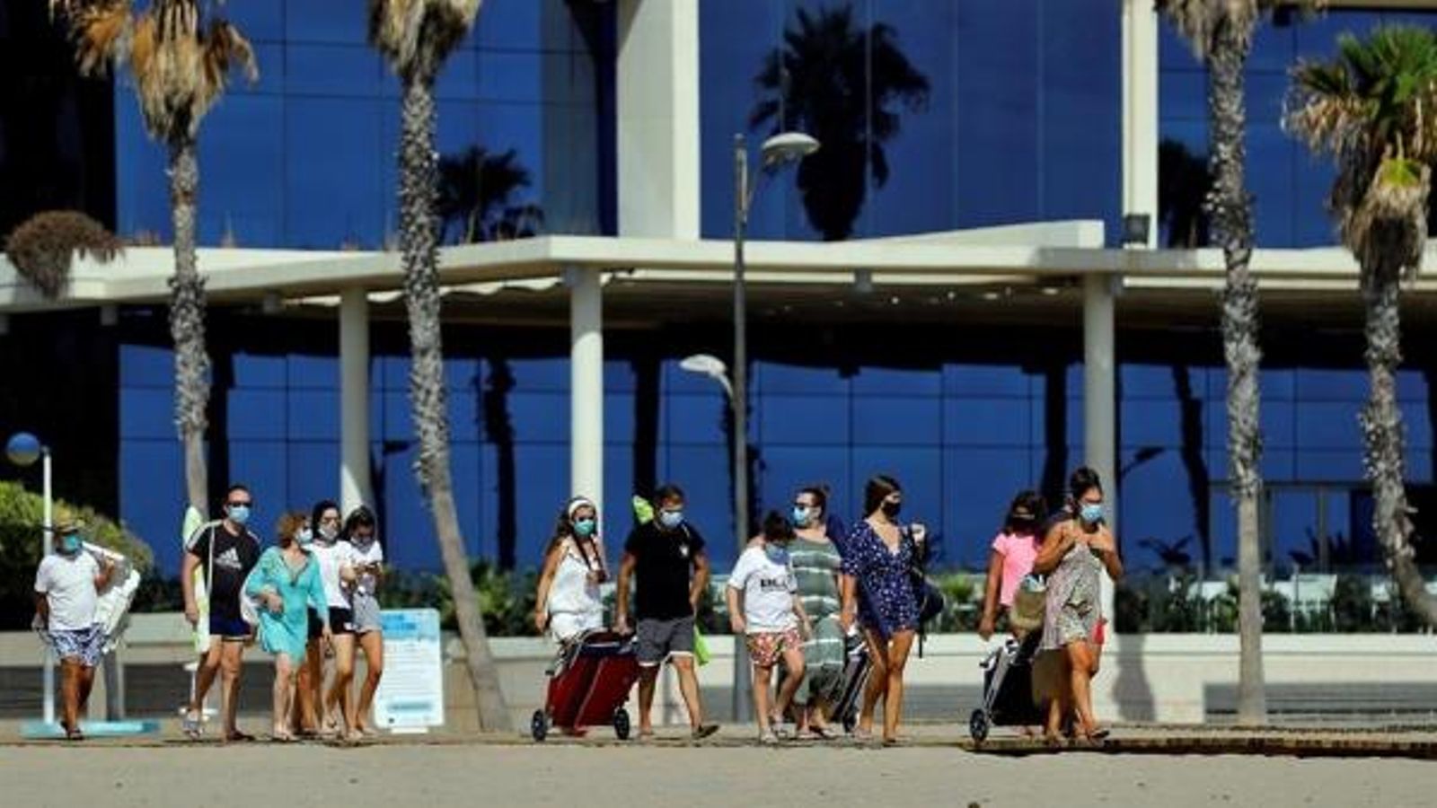 Diverses persones amb mascareta a la platja de la Patacona