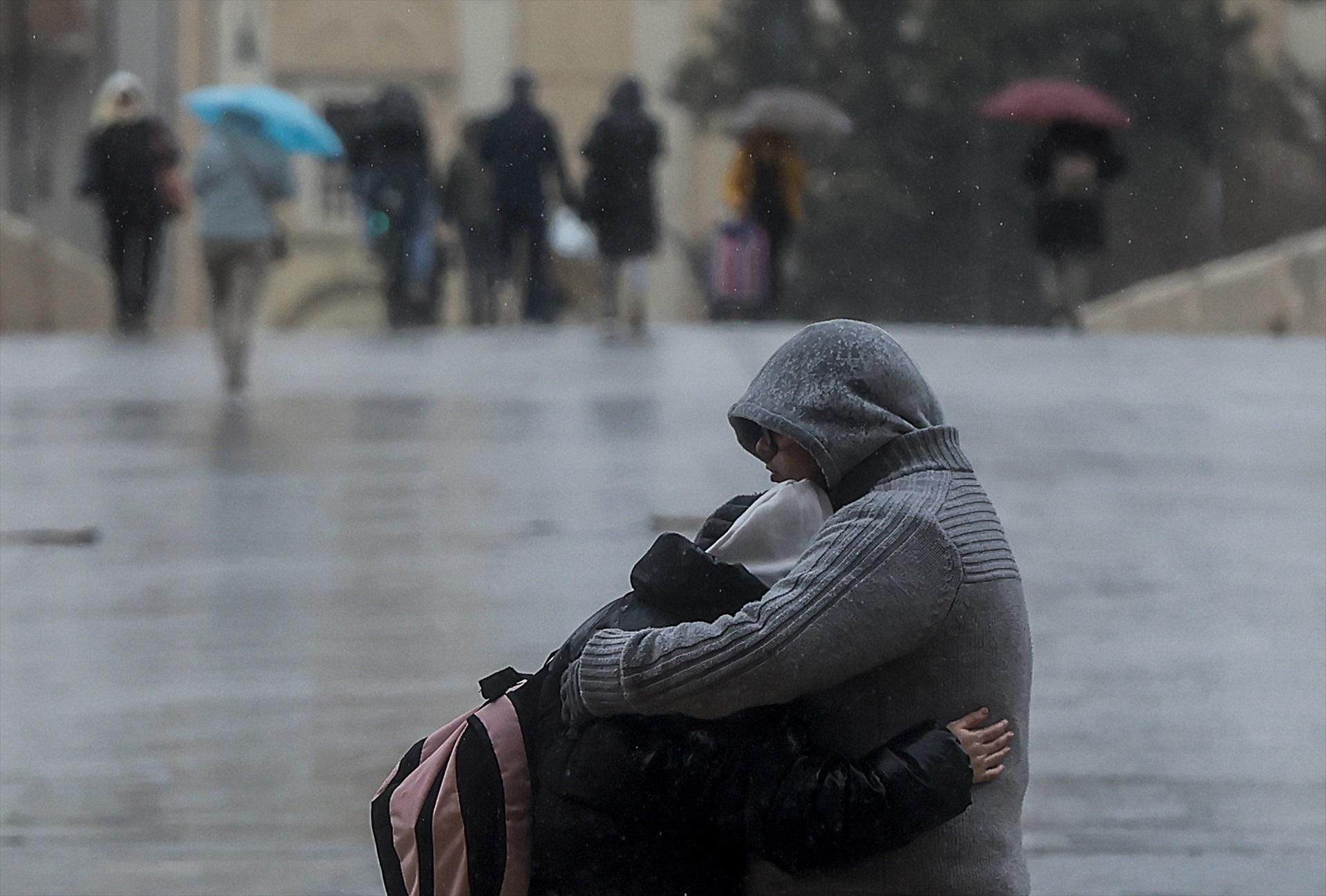 Una parella s'abraça davall de la pluja, en una imatge d'arxiu a València Una parella s'baraça sota la pluja en una imtge d'arxiu