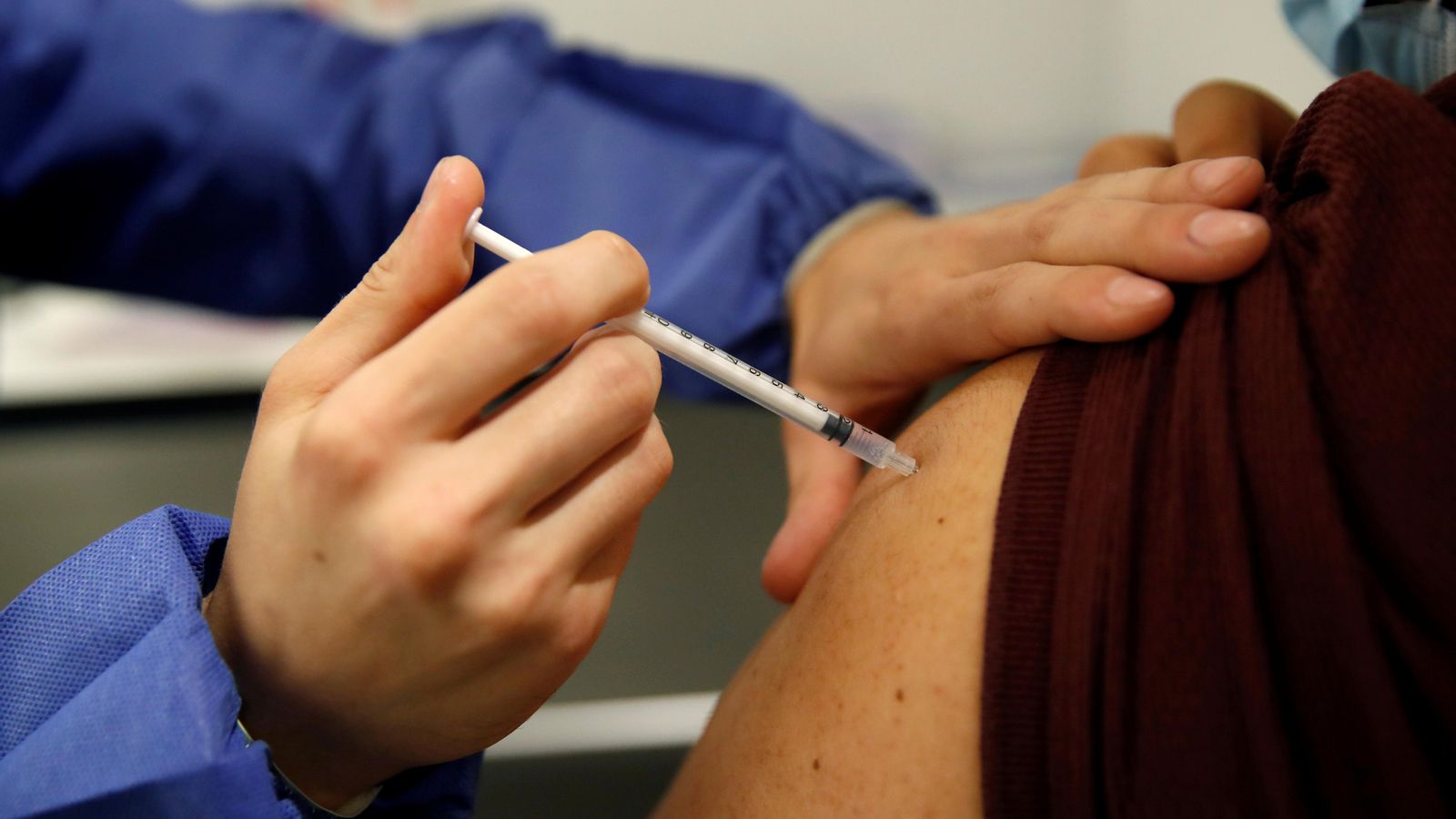 Un sanitari vacuna a una persona contra el coronavirus