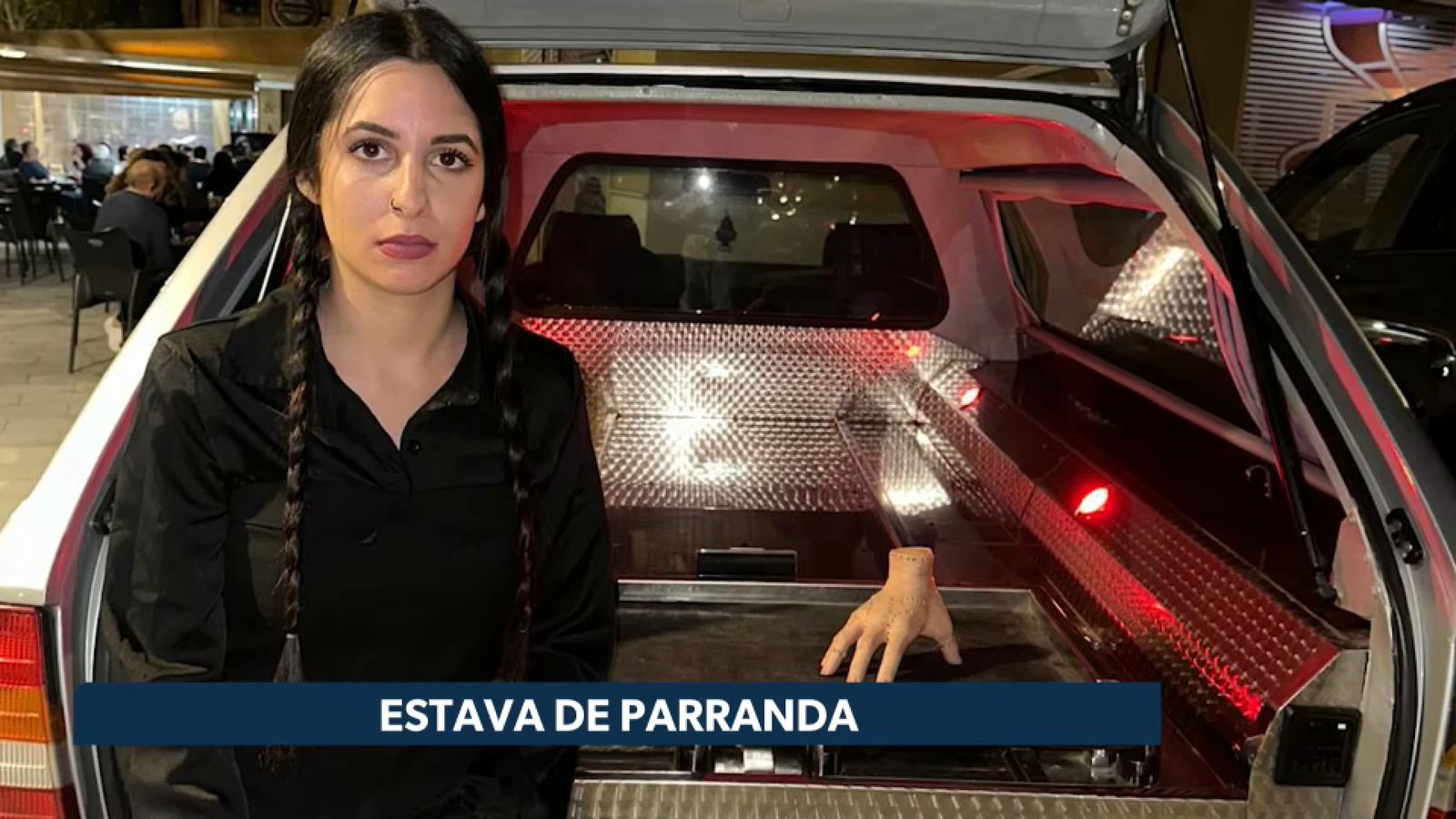 Una veïna de Petrer es disfresa de Dimecres Adams davant del polèmic cotxe fúnebre