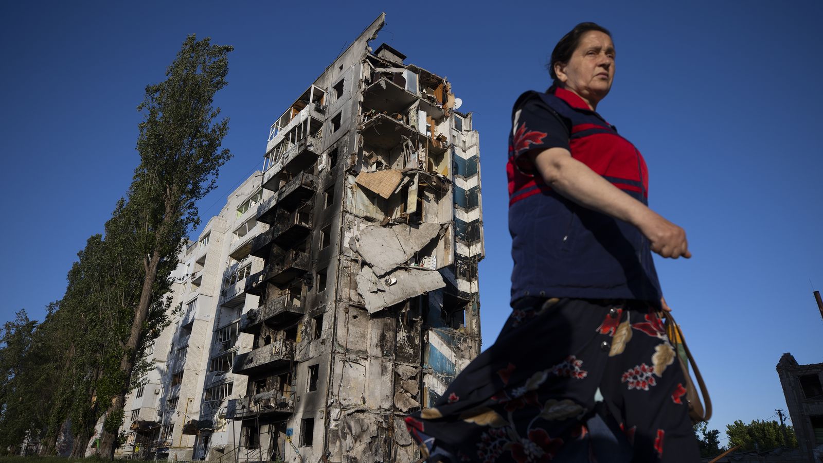 Una dona camina al costat d'un edifici destruït pels bombardejos russos, a Borodyanka (Ucraïna)