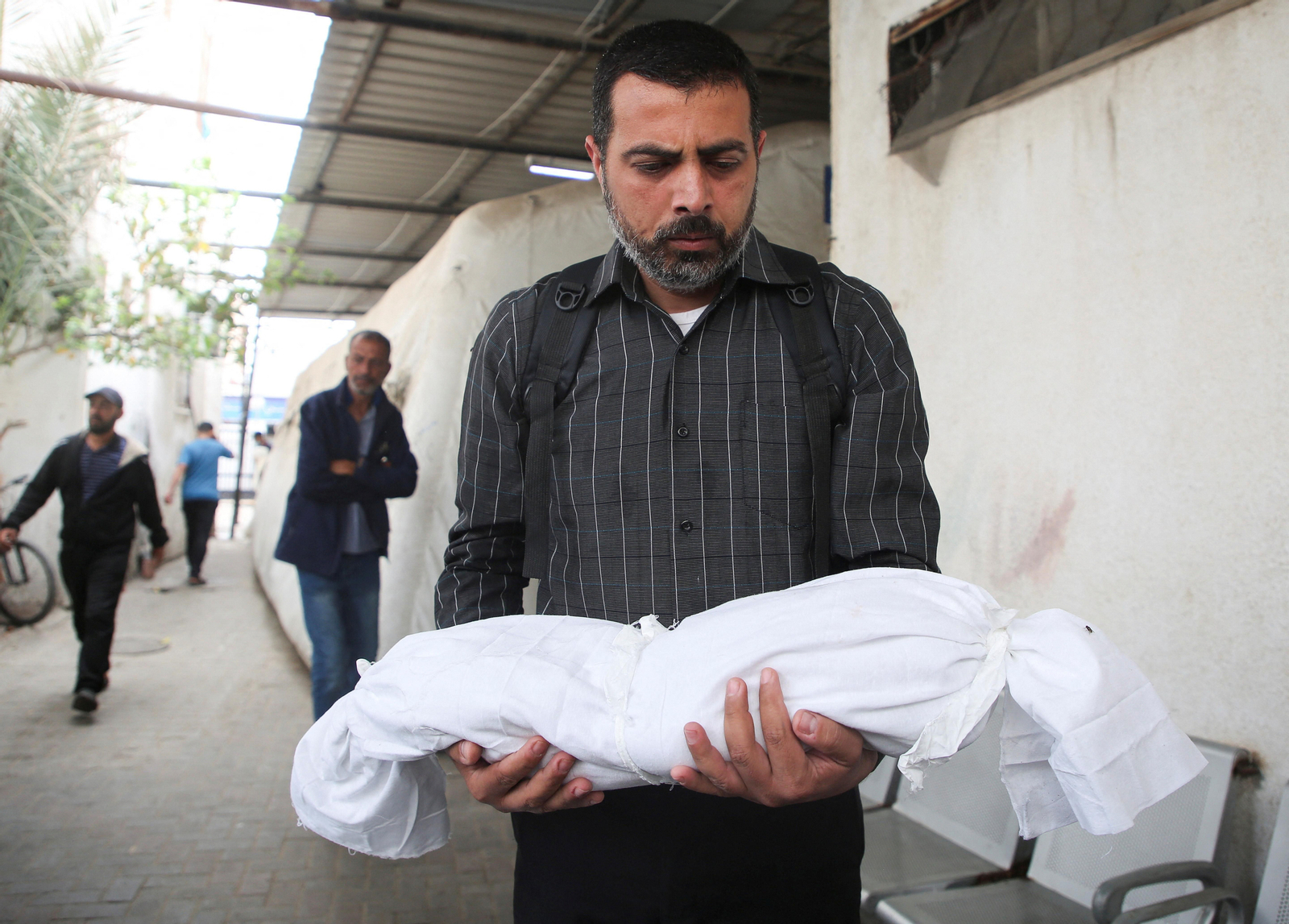 Un home trasllada el cadàver d'un menut mort en un bombardeig israelià sobre Rafah