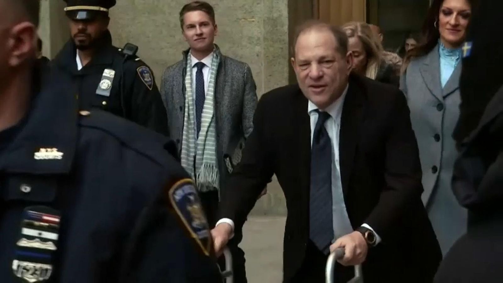 El productor cinematogràfic Harvey Weinstein abandona la sala on el jutgen, acompanyat dels seus advocats