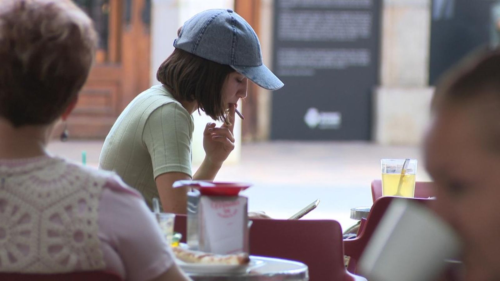 Una dona fuma en la terrassa d'un establiment