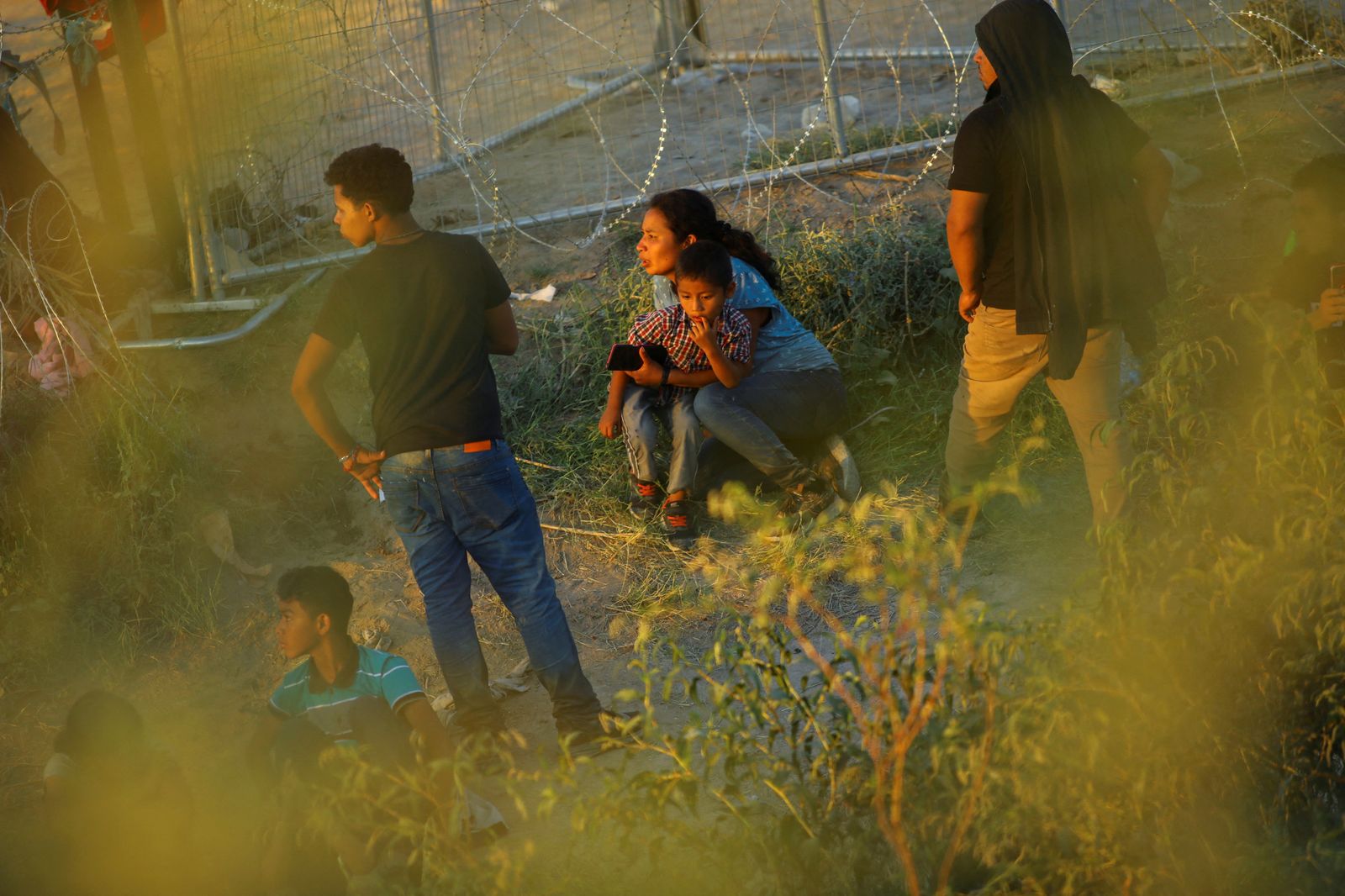 Un grup de migrants retinguts per la Guàrdia Nacional dels EUA espera durant hores una decisió sobre el seu futur