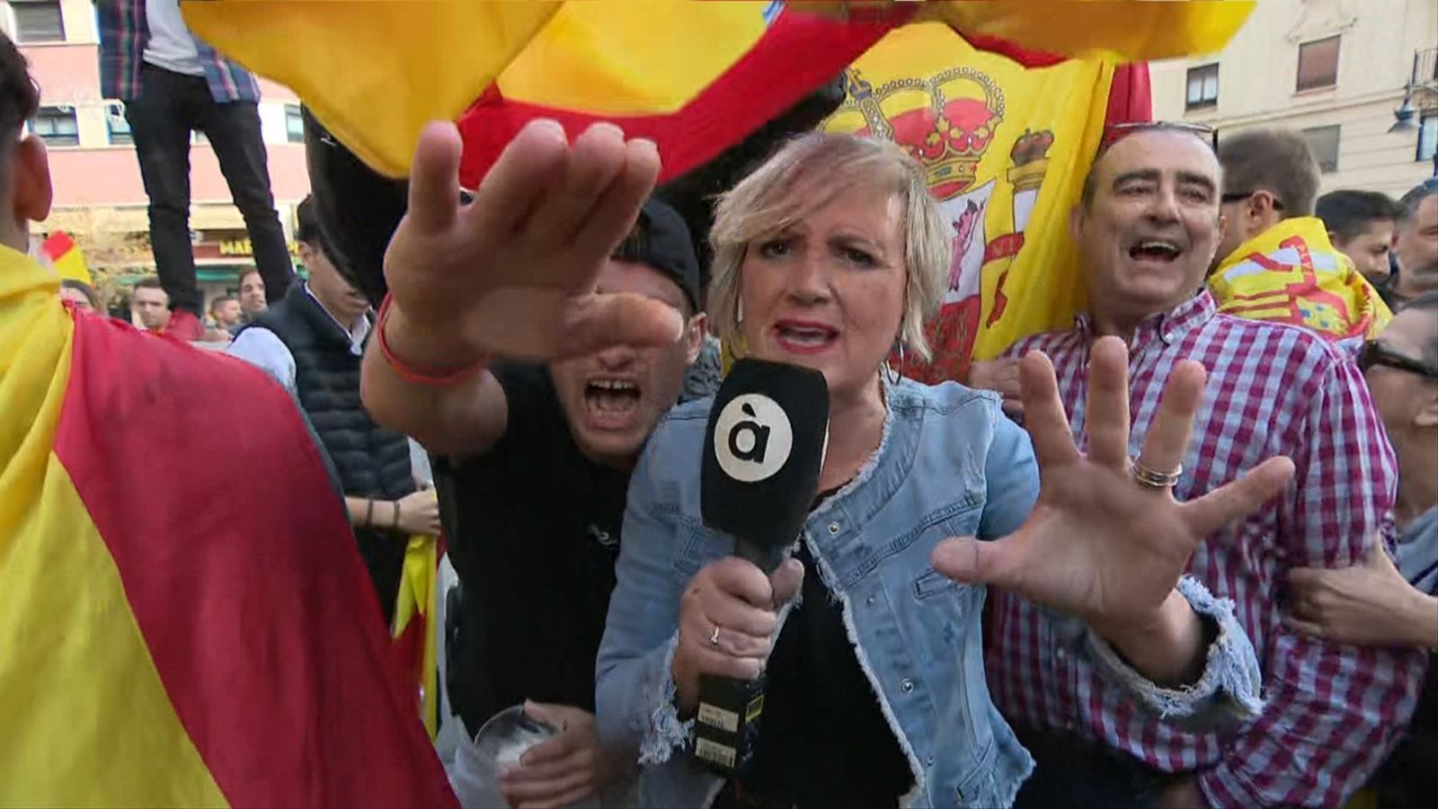 Un grup de manifestants assetja l'equip d'À Punt durant una connexió en directe a la manifestació convocada per Vox davant de la seu del PSPV a València / À Punt NT