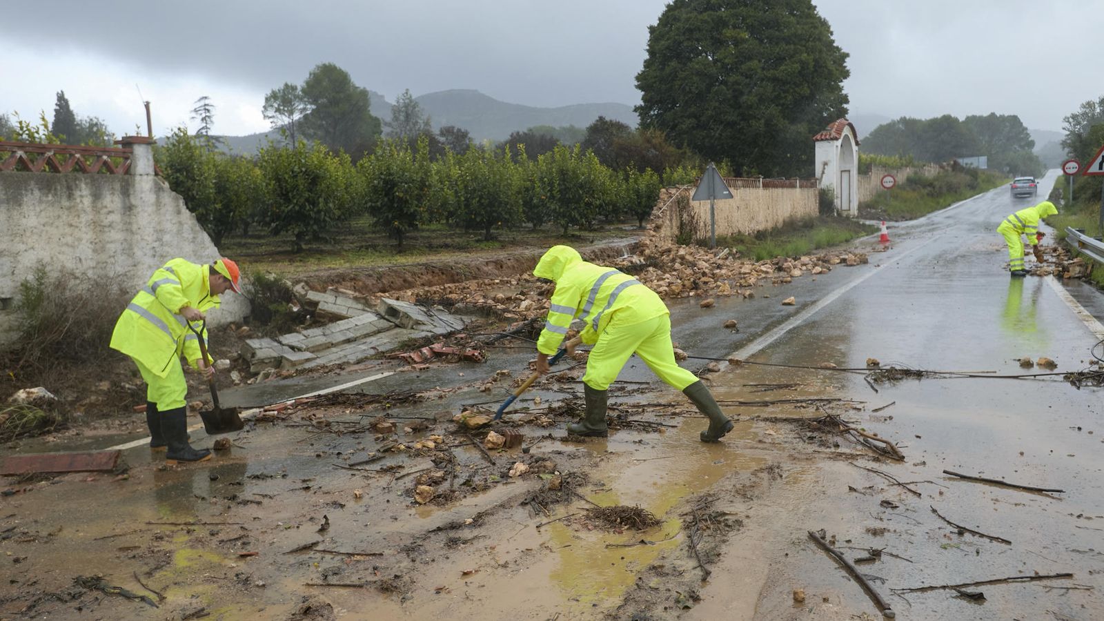 Operaris netegen la carretera d'accés a Manuel, a la Ribera Alta