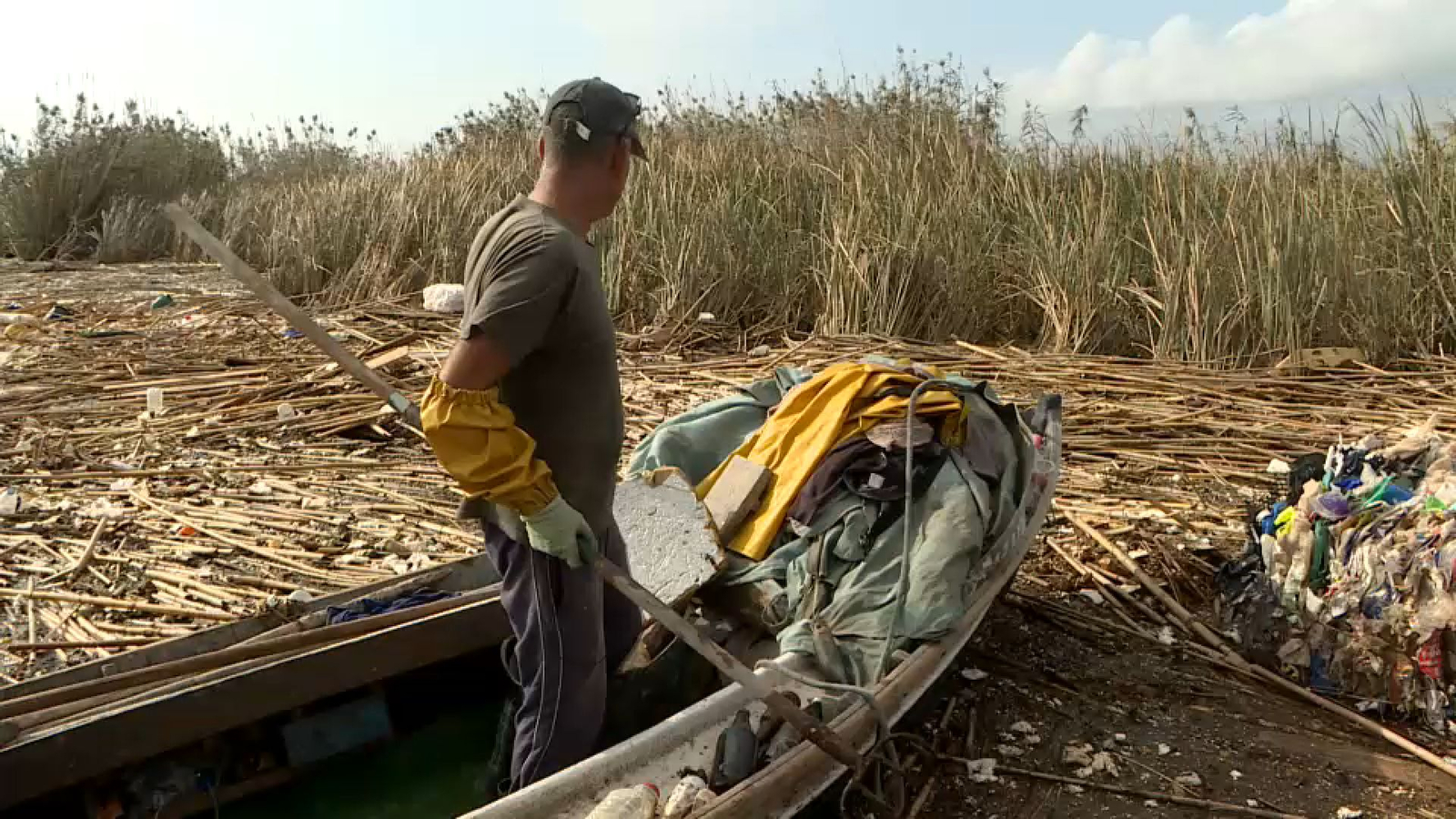 Nelo, un dels pescadors de l'Albufera, arreplega residus en la seua barca