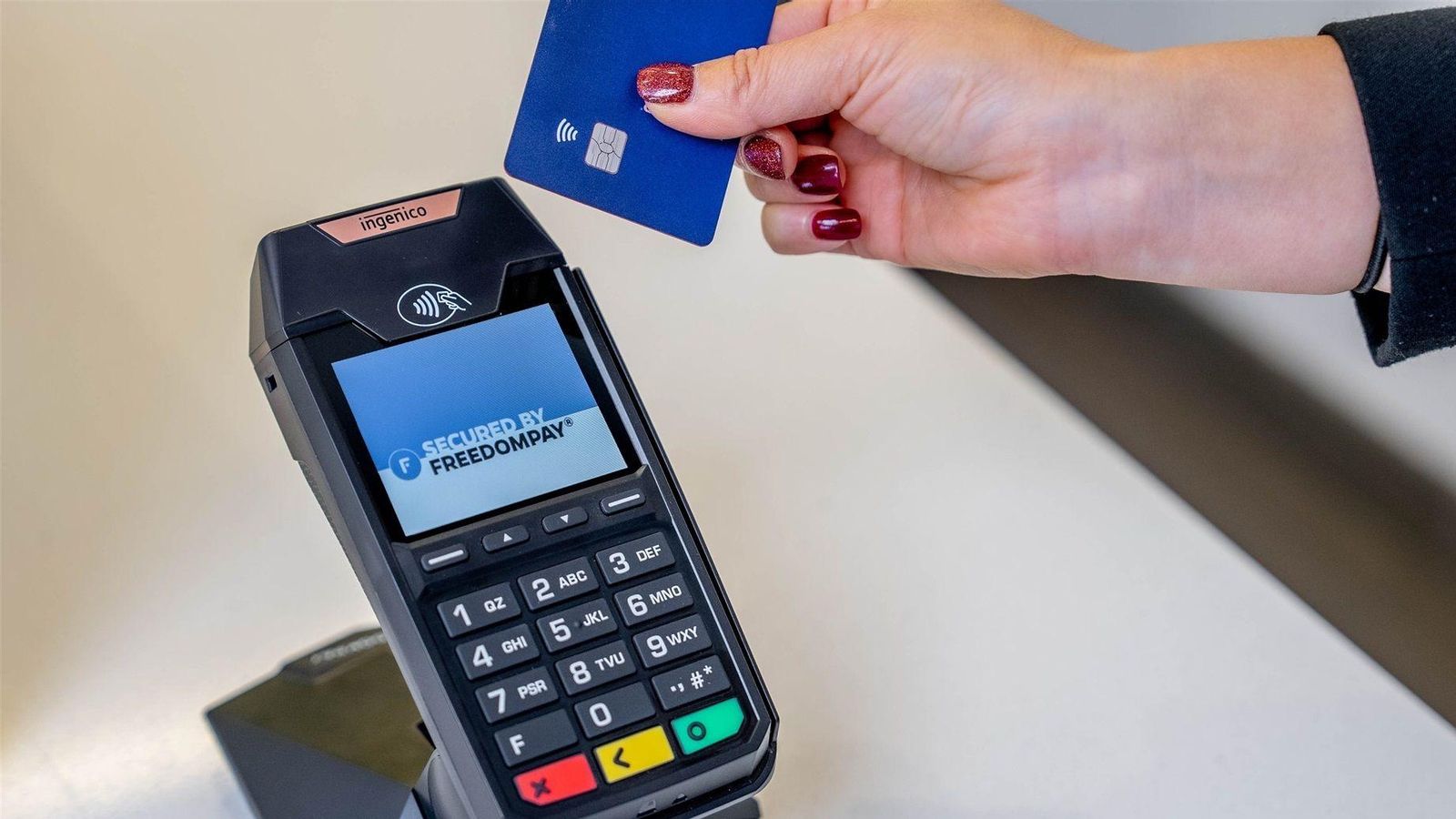 Una dona pagant amb targeta en un datàfon Una dona pagant amb targeta en un datàfon