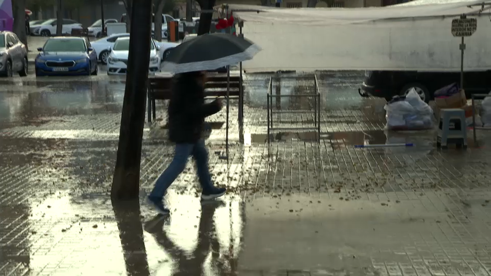 Un home es protegeix de la pluja amb un paraigua