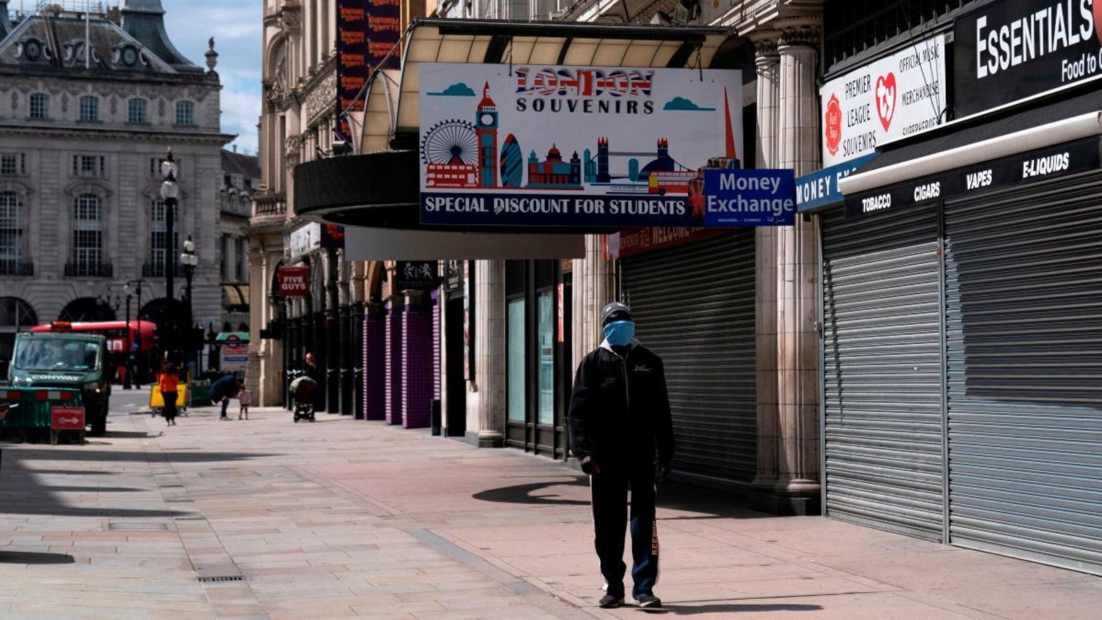 Un viananant creua un carrer del Regne Unit, amb els comerços encara tancats