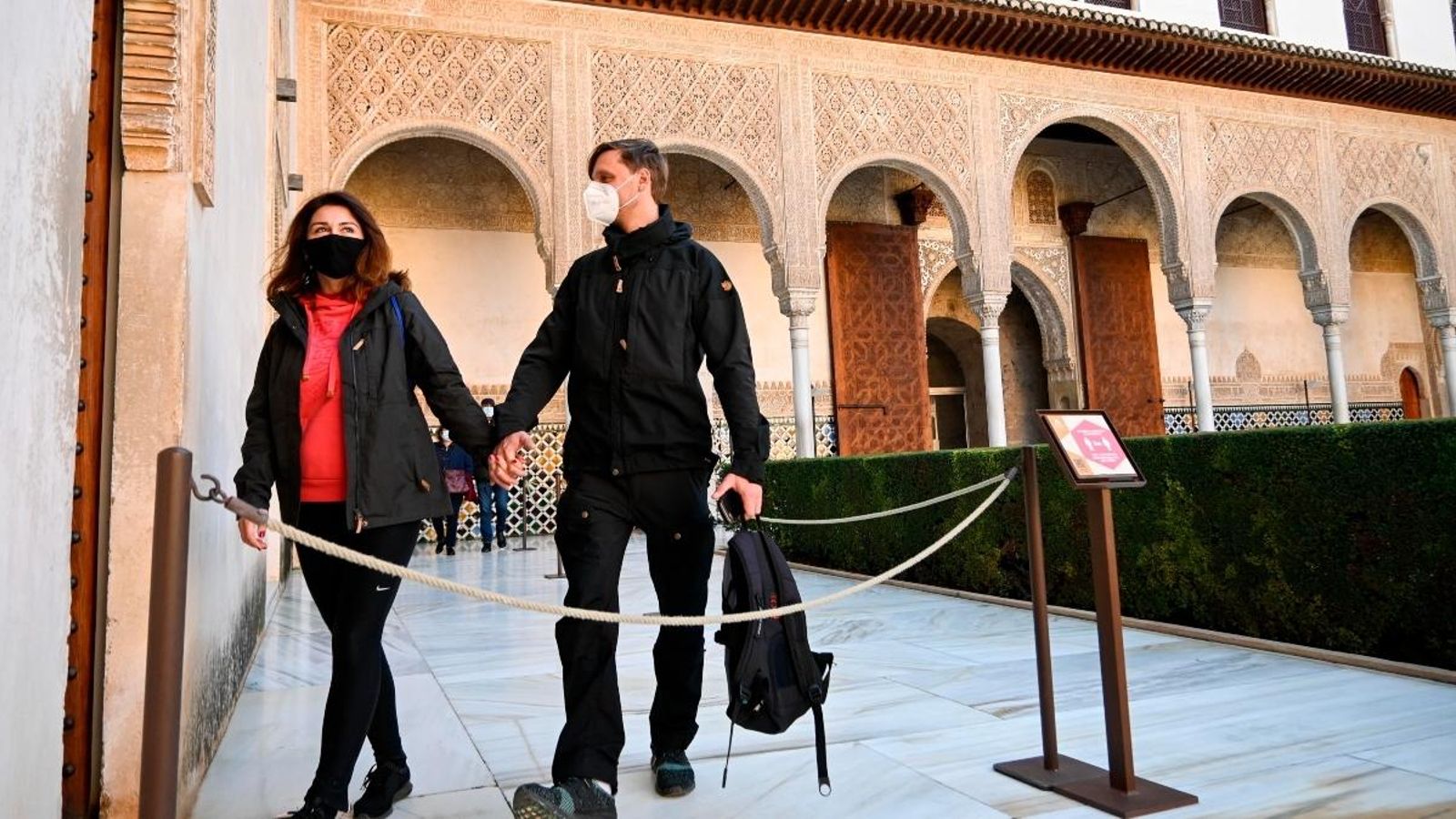 Una parella de visitants creuen un dels patis de l'Alhambra de Granada aquest dimarts, quan a reobert aquest monument