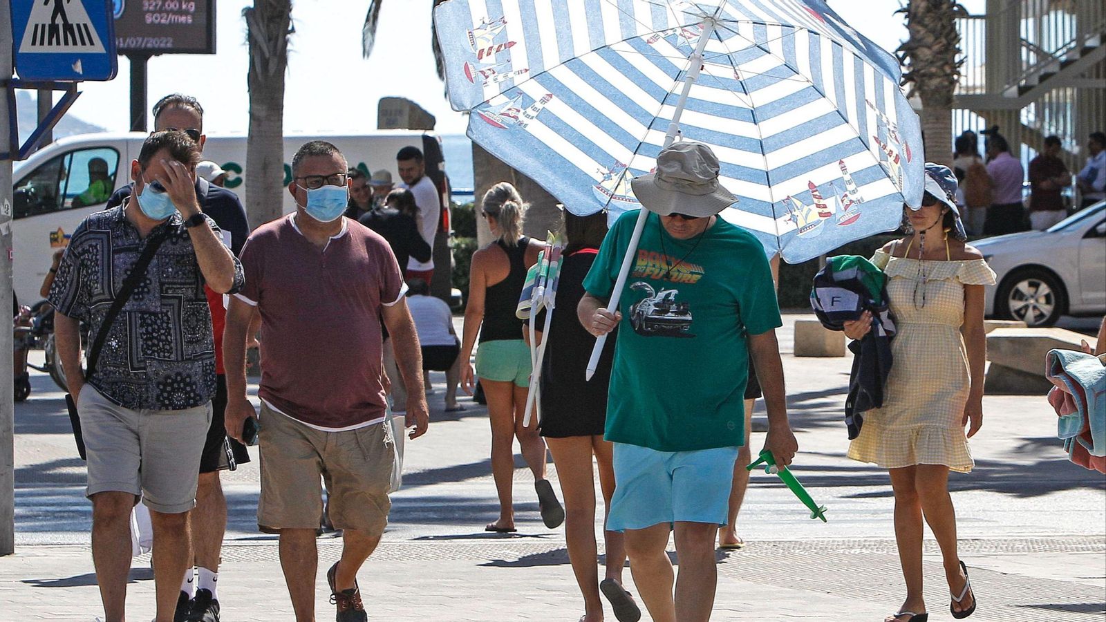 Un home es protegeix del sol amb un parasol a Alacant