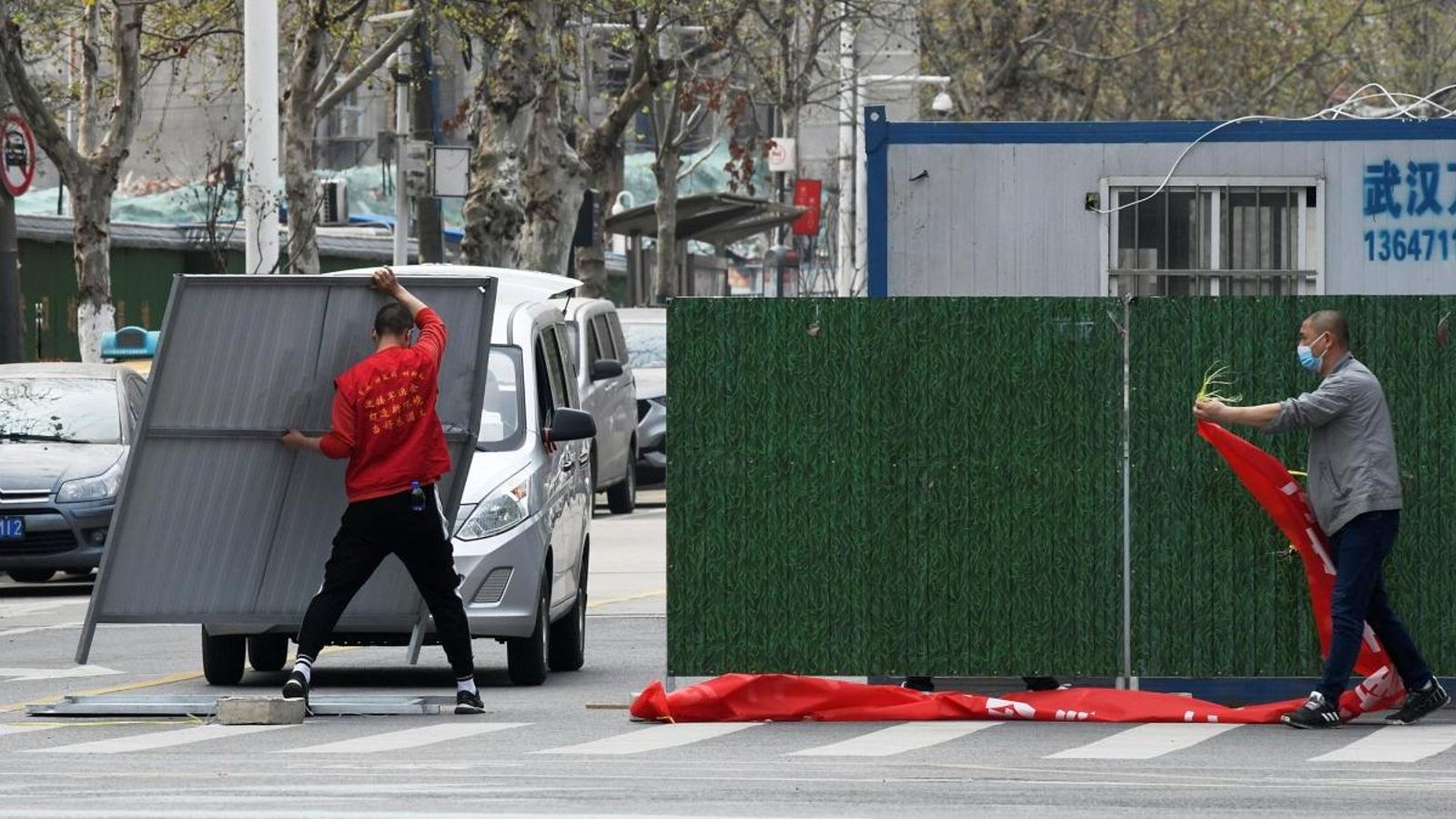 Treballadors eliminen barreres en un carrer en Wuhan, després que la ciutat haja començat a afluixar el tancament, a la província de Hubei, la Xina