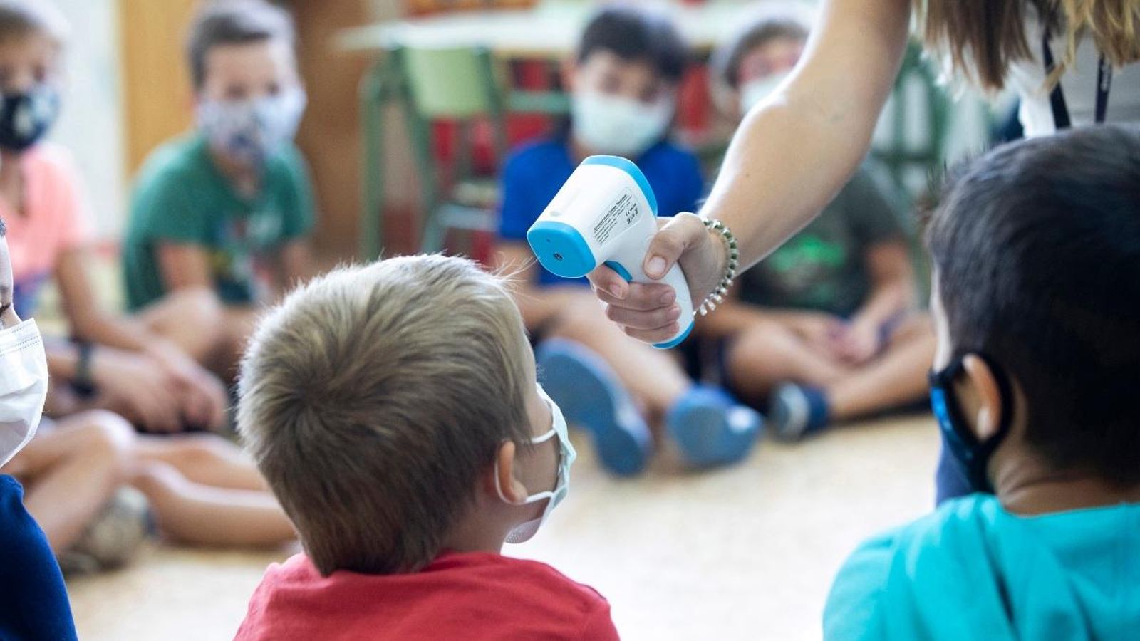 Una professora pren la temperatura a un alumne