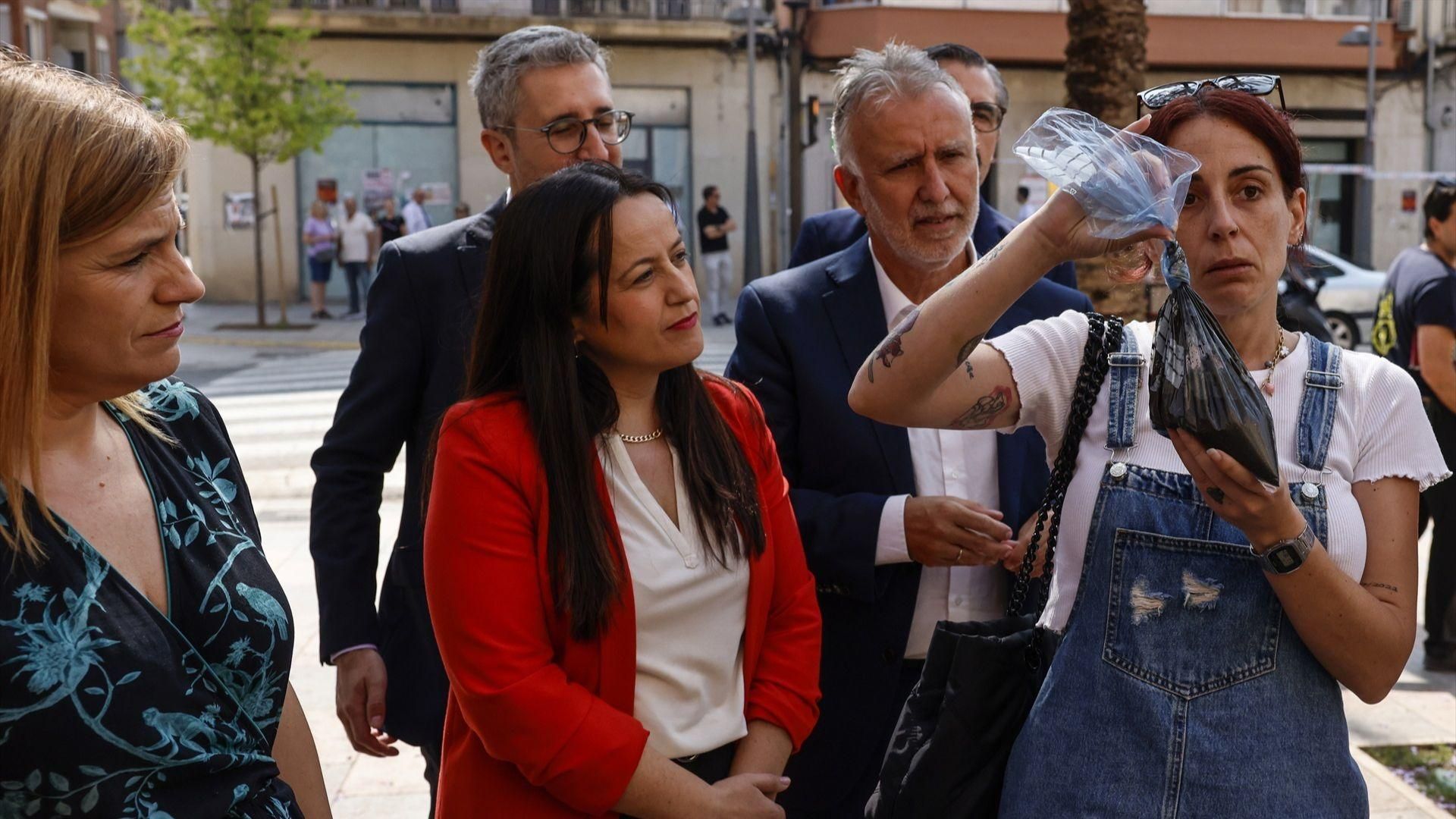 Una veïna ensenya una bossa amb restes de fang al ministre Ángel Víctor Torres, este dimecres a Catarroja Una veïna ensenya una bossa amb restes de fang al ministre Ángel Víctor Torres, este dimecres a Catarroja