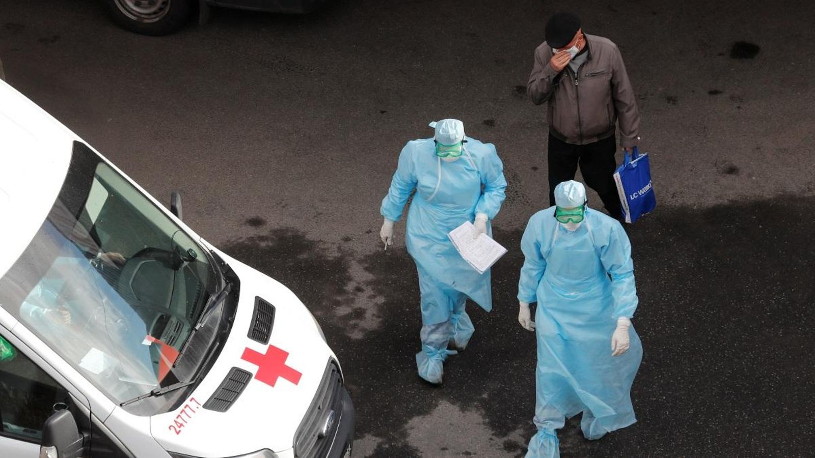 Dos sanitaris acompanyen a un pacient amb Covid-19 a San Petersburg