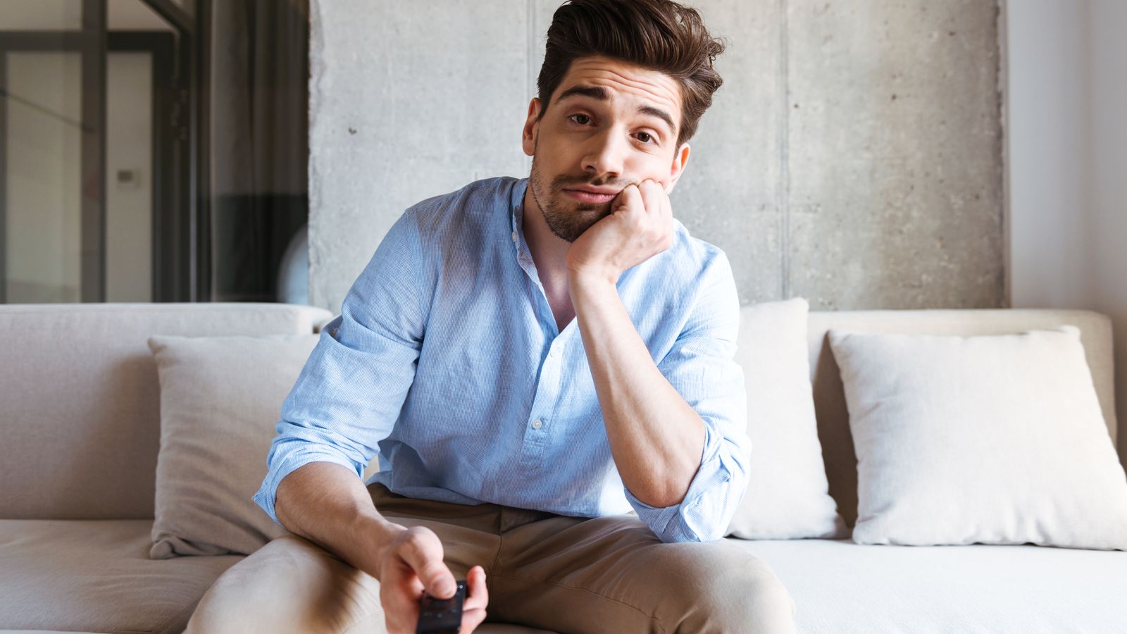 Un home mira la televisió amb cara avorrida