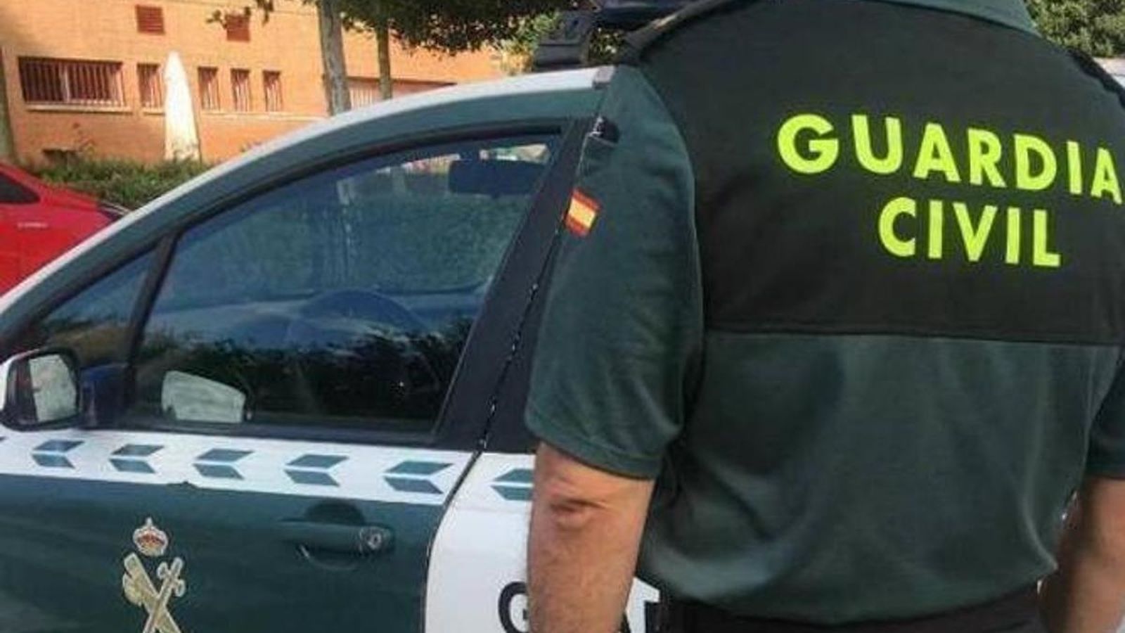 Imatge d'arxuy d'un agent de la Guàrdia Civil davant un cotxe patrulla