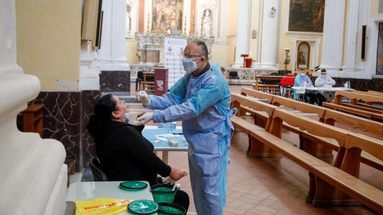 Un metge realitza una prova de coronavirus a una dona a una església de Nàpols, Itàlia, aquest dimecres