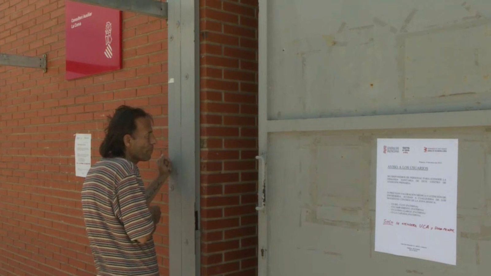 Un usuari del centre de salut pregunta a les portes, tancades, de l'ambulatori que dona servei a aquest barri de Paterna