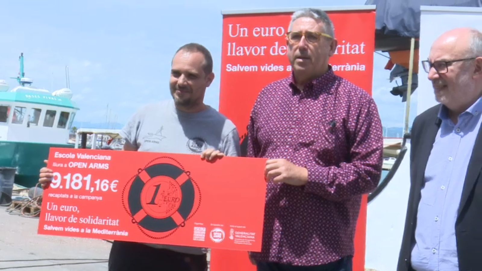 El patró de l'Open Arms, Marc Reig, a l'esquerra, en el moment d'arreplegar el xec d'Escola Valenciana.