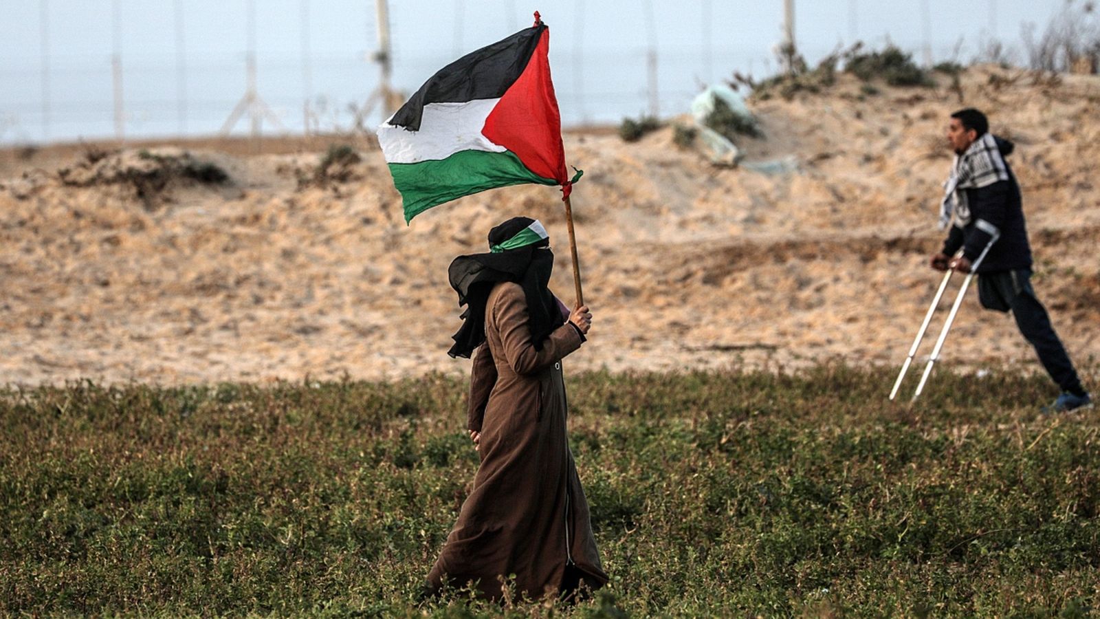 Una manifestant porta una bandera nacional palestina durant els enfrontaments d'aquest dimarts amb l’exèrcit israelià a la Franja de Gaza