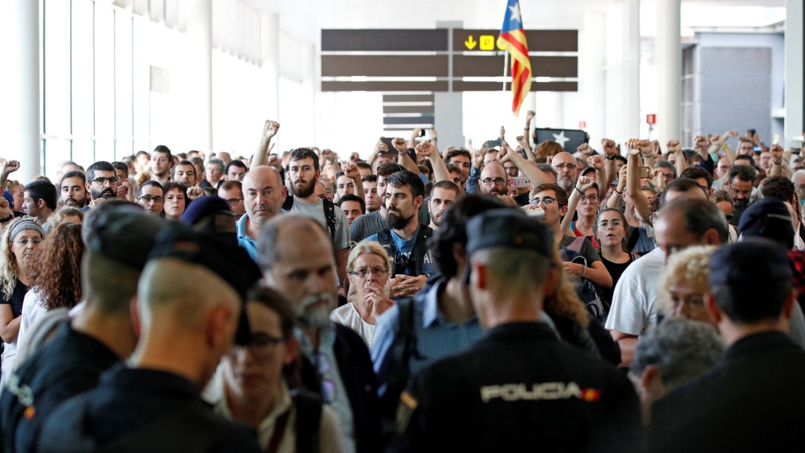 Agents dels Mossos d’Esquadra i de la Policia Nacional controlen l’accés a la terminal 1 de l’aeroport del Prat