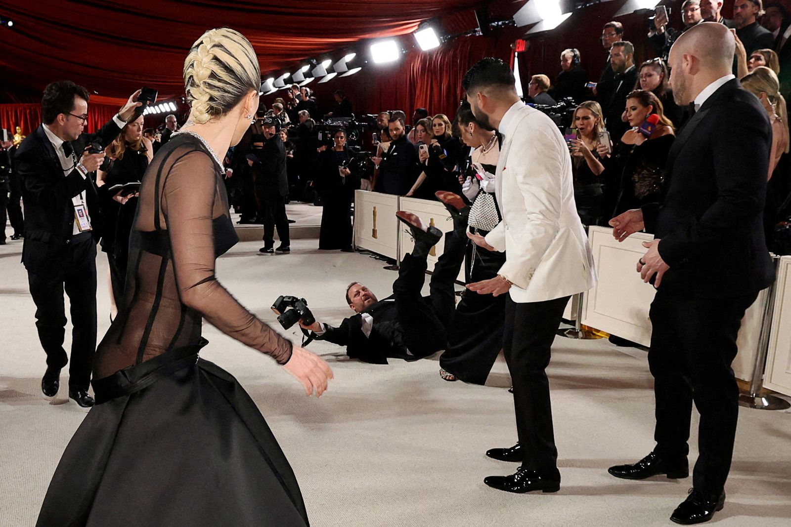 Lady Gaga reacciona mentre un fotògraf cau sobre la catifa roja durant les arribades dels Oscar, Los Angeles, els EUA, 12 de març del 2023