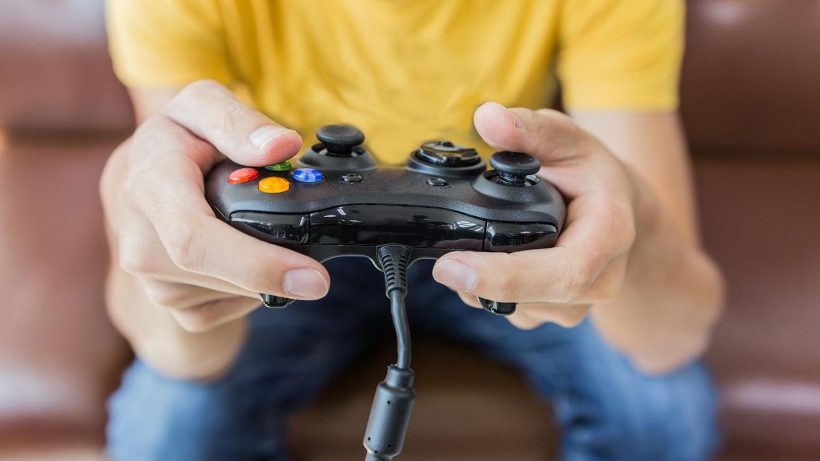 Un adolescent agafa el comandament d'una videoconsola