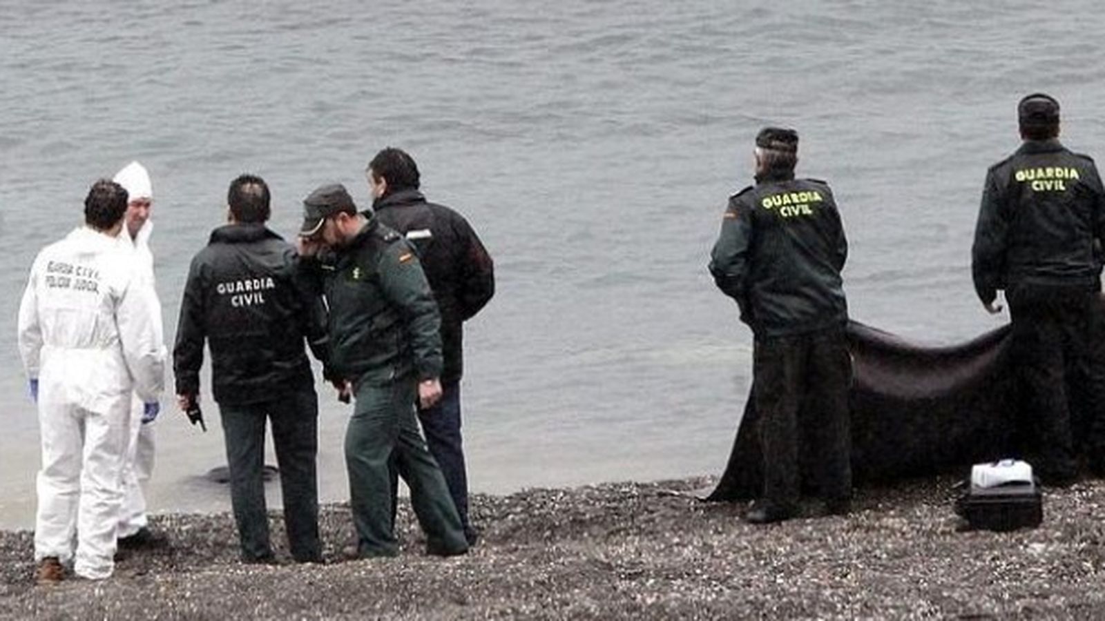Els agents recuperen els cossos dels migrants en la platja del Tarajal, a Ceuta, en una imatge d'arxiu