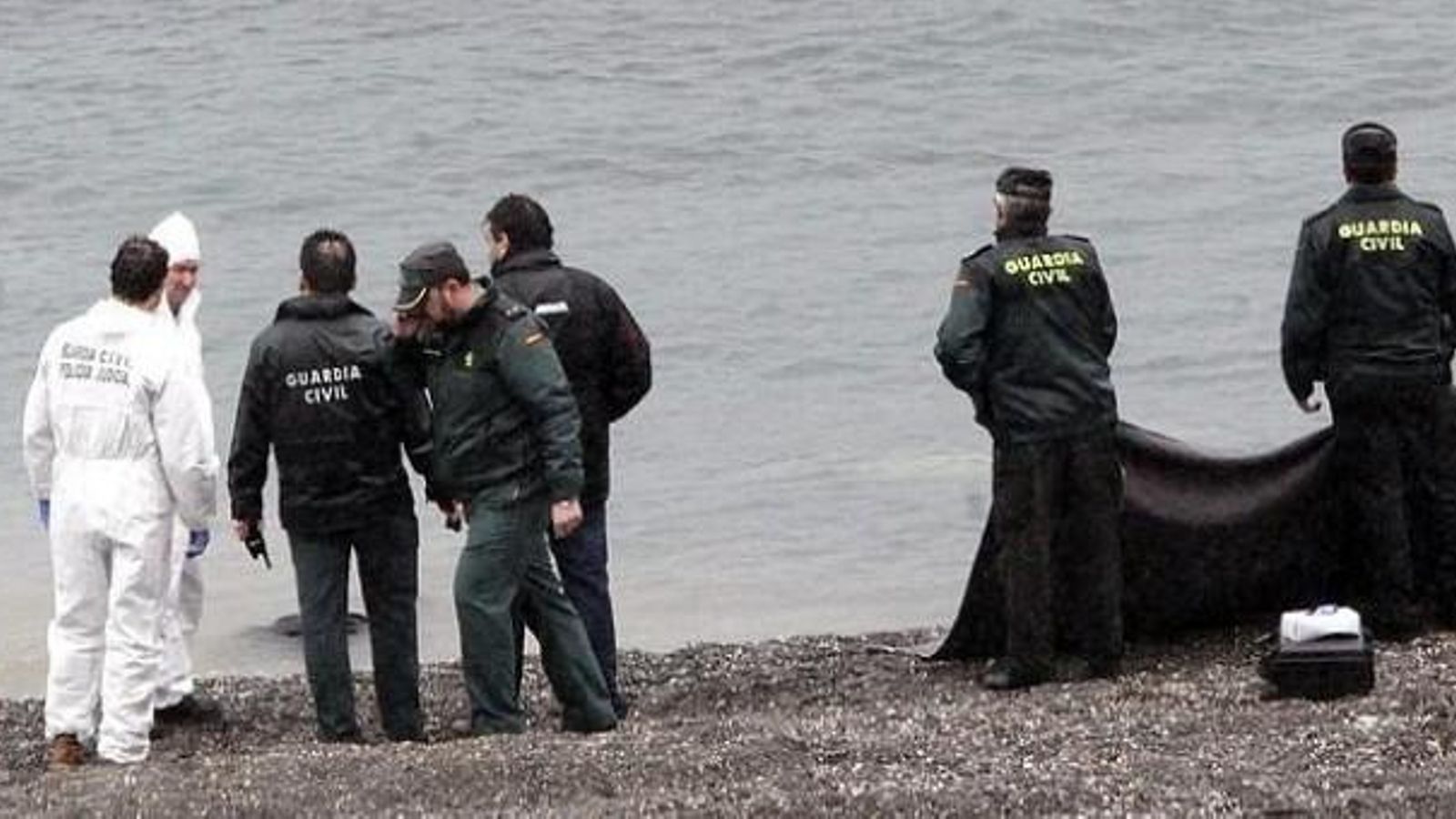 Els agents recuperen els cossos dels migrants en la platja del Tarajal, a Ceuta, en una imatge d'arxiu Els agents recuperen els cossos dels migrants en la platja del Tarajal, a Ceuta, en una imatge d'arxiu